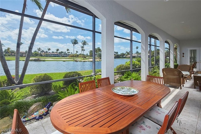 sunroom featuring a water view