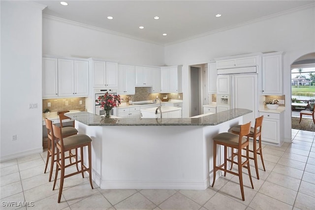 kitchen featuring ornamental molding, a breakfast bar area, light tile patterned floors, and a large island
