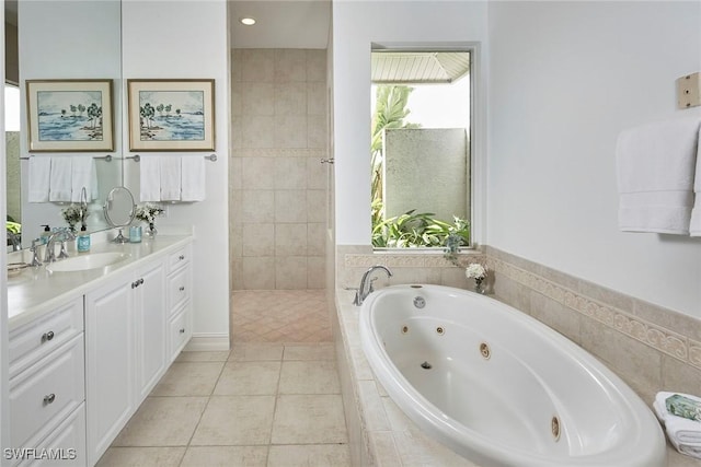 bathroom featuring a jetted tub, vanity, and tile patterned flooring