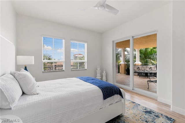 bedroom featuring access to exterior, a ceiling fan, baseboards, and wood finished floors