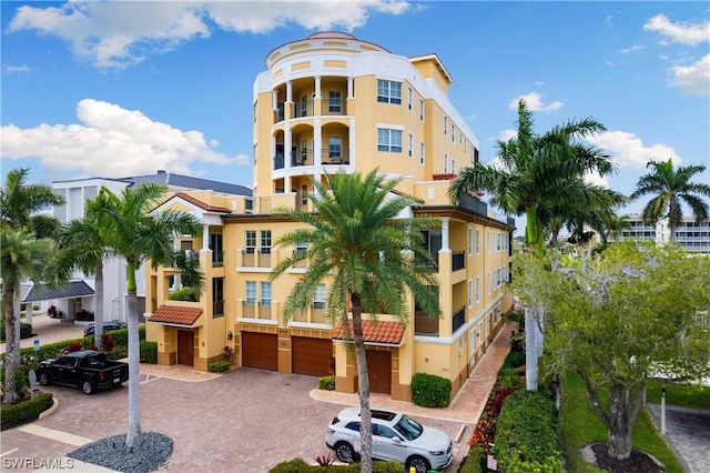 view of property featuring an attached garage and decorative driveway