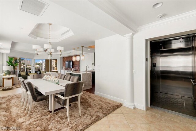 tiled dining room featuring a raised ceiling, elevator, an inviting chandelier, and crown molding