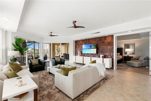 tiled living room featuring ceiling fan and crown molding