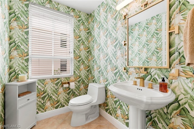 bathroom with baseboards, tile patterned floors, toilet, and wallpapered walls