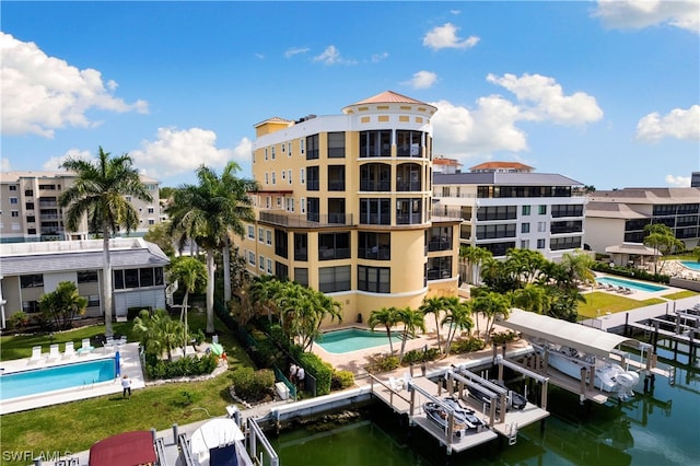 view of building exterior featuring a water view and a community pool