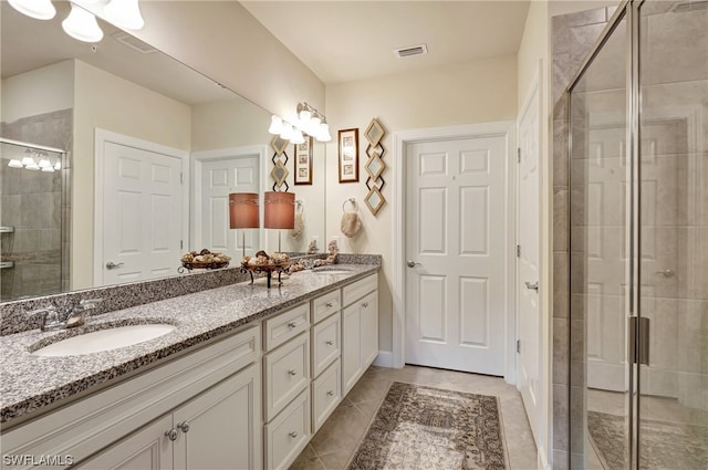 bathroom featuring tile floors, double sink, an enclosed shower, and oversized vanity