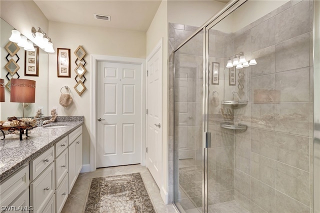 bathroom featuring a shower with door, large vanity, and tile flooring