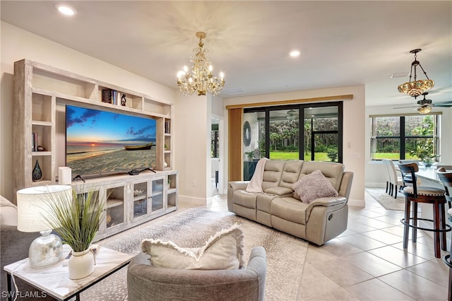 tiled living room with ceiling fan with notable chandelier and built in shelves