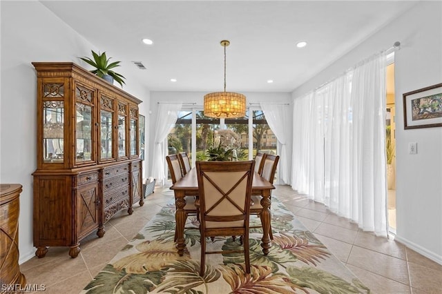 dining room with light tile patterned floors and a notable chandelier