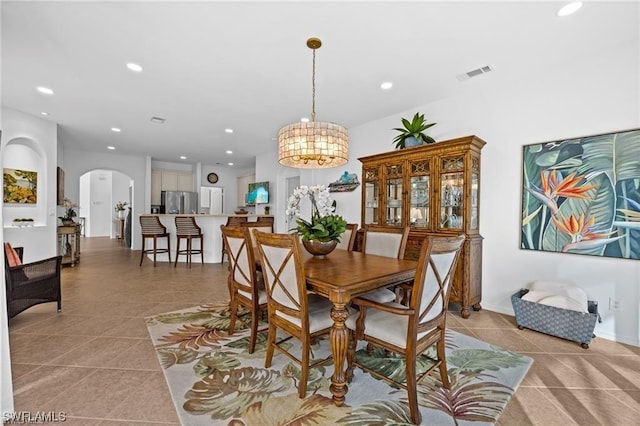 tiled dining area featuring a notable chandelier