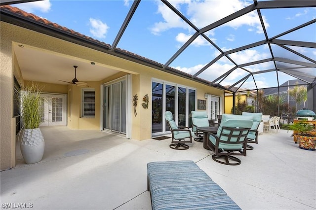 view of patio with a lanai, ceiling fan, and french doors