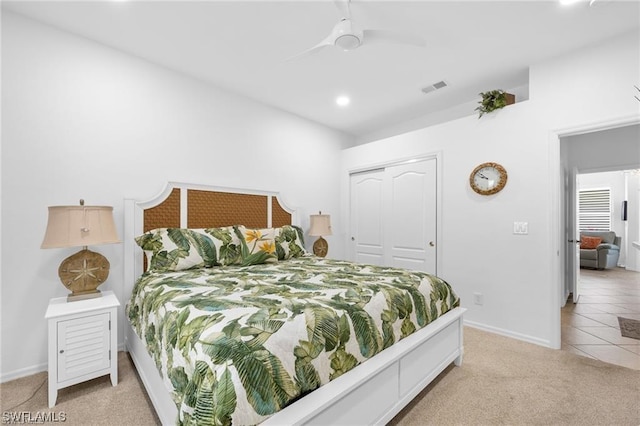 carpeted bedroom with ceiling fan and a closet