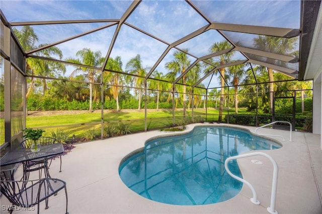 view of pool featuring a yard, glass enclosure, and a patio area