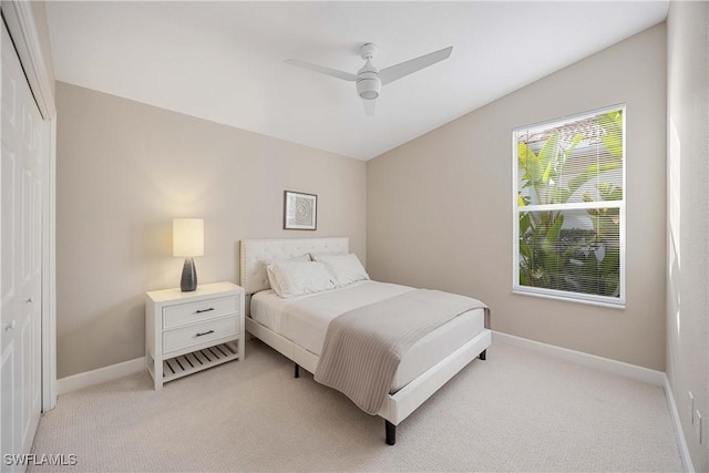 carpeted bedroom featuring ceiling fan, lofted ceiling, and a closet