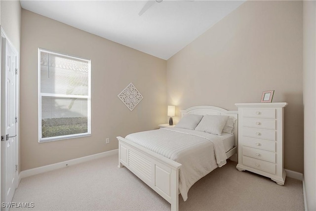 bedroom featuring ceiling fan, light colored carpet, and multiple windows