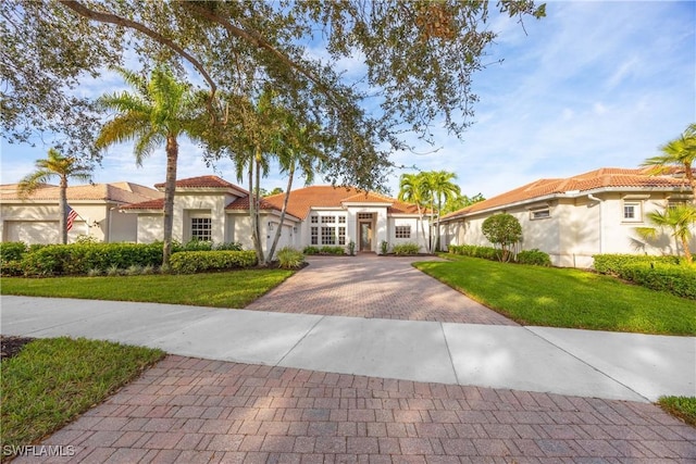 mediterranean / spanish home featuring a front lawn