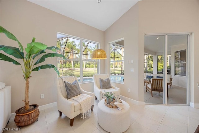 sitting room with light tile patterned flooring and high vaulted ceiling