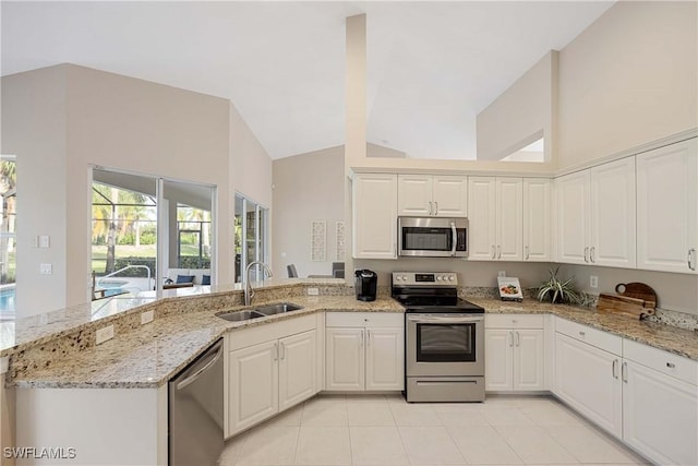 kitchen featuring light stone countertops, sink, white cabinets, and appliances with stainless steel finishes