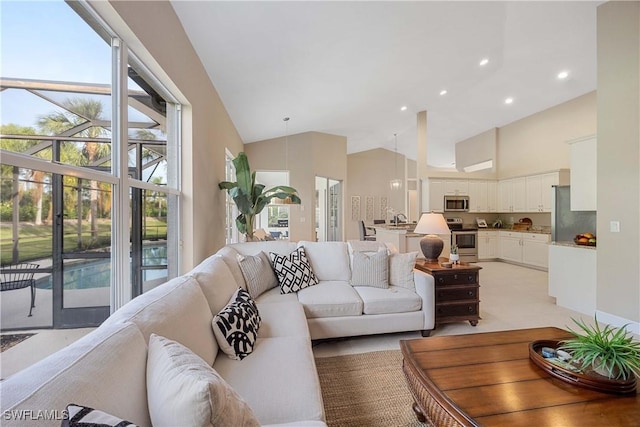 living room featuring sink and high vaulted ceiling