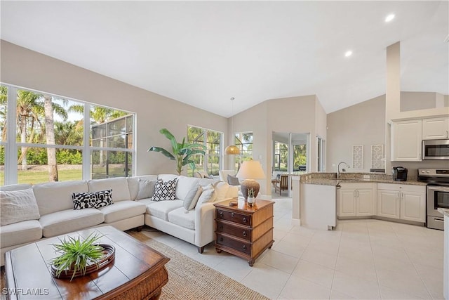 tiled living room featuring sink and high vaulted ceiling