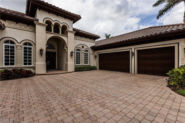 mediterranean / spanish-style home with a garage