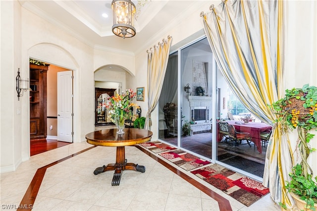 hall with tile patterned flooring, a notable chandelier, and ornamental molding