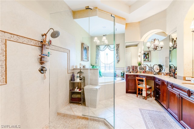 bathroom with tile patterned flooring, a chandelier, vanity, independent shower and bath, and tile walls