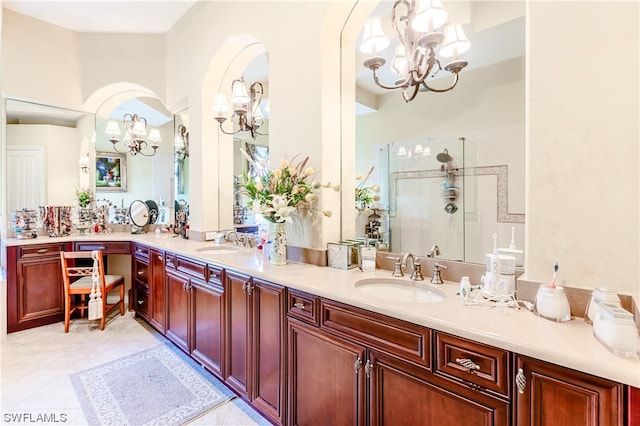 bathroom featuring tile patterned floors, a notable chandelier, an enclosed shower, and vanity