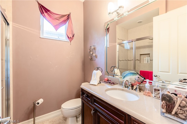 bathroom with vanity, toilet, and a shower with shower door