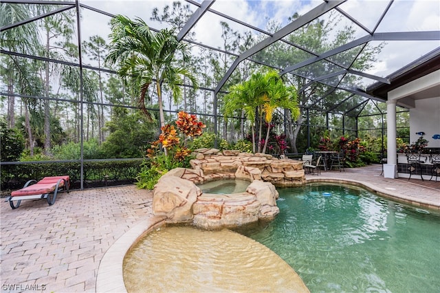 view of swimming pool featuring a patio and a lanai