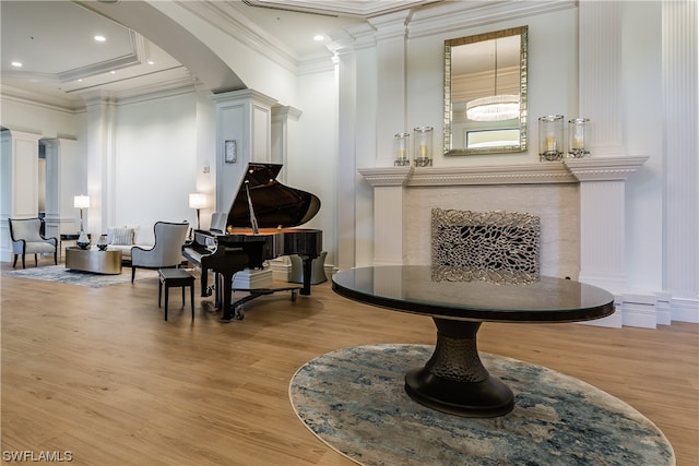 misc room with light wood-type flooring, ornamental molding, a high end fireplace, and ornate columns