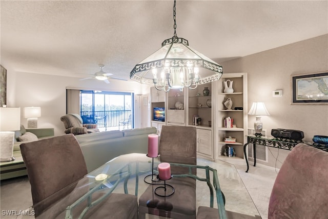 dining room featuring a textured ceiling, ceiling fan with notable chandelier, and light colored carpet