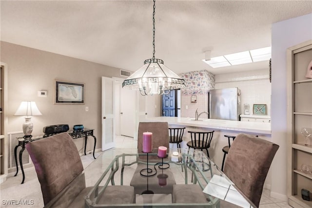 dining space with visible vents, a textured ceiling, and light tile patterned flooring