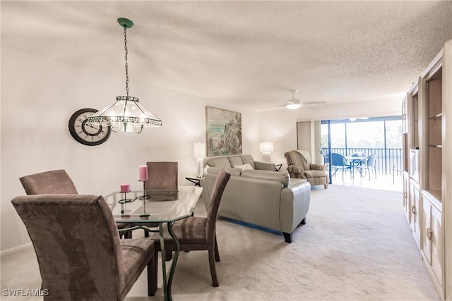 dining room featuring ceiling fan, a textured ceiling, and light colored carpet