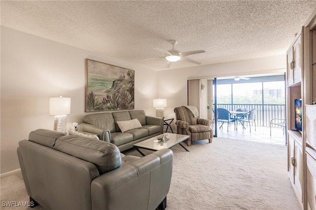 living area with ceiling fan, a textured ceiling, baseboards, and light colored carpet