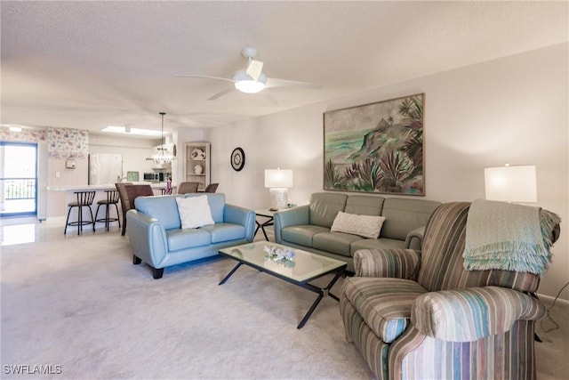 living room with carpet floors, ceiling fan, and a textured ceiling