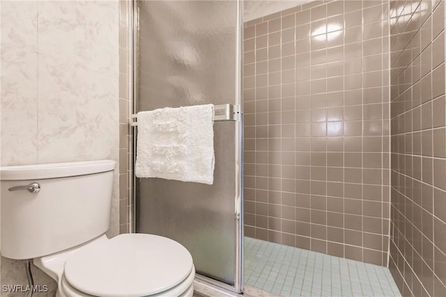 bathroom with a shower stall and toilet