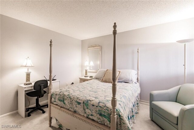 bedroom with a textured ceiling, baseboards, and light colored carpet