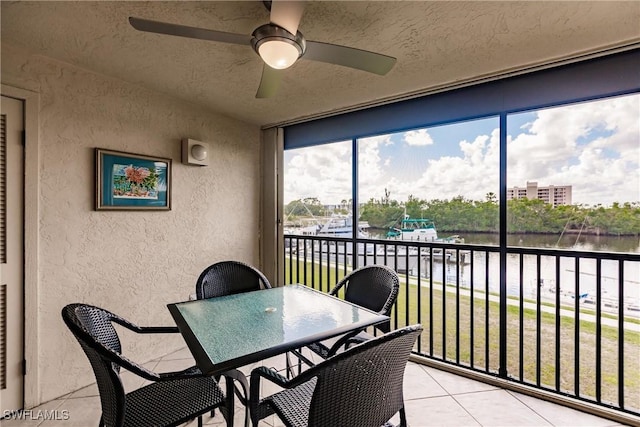 sunroom with a water view and ceiling fan