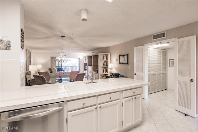 kitchen with a sink, visible vents, white cabinetry, open floor plan, and dishwasher