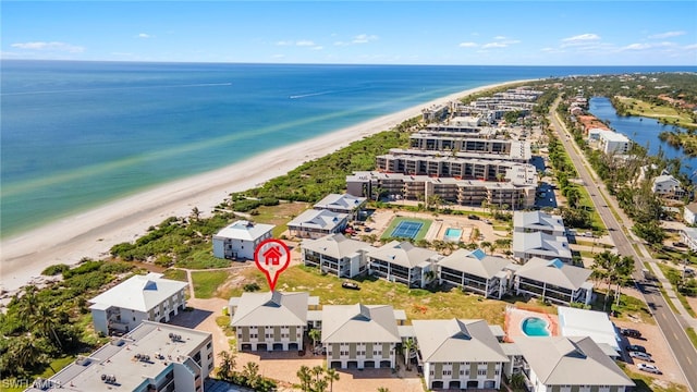 drone / aerial view featuring a water view and a beach view