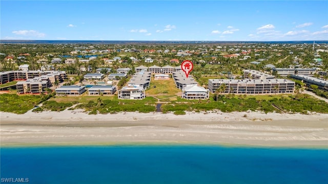 birds eye view of property featuring a water view and a beach view