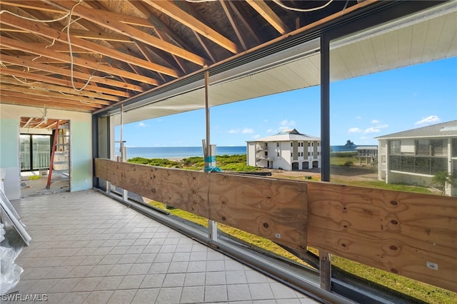 sunroom / solarium featuring a water view