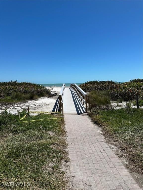 view of property's community with a beach view and a water view