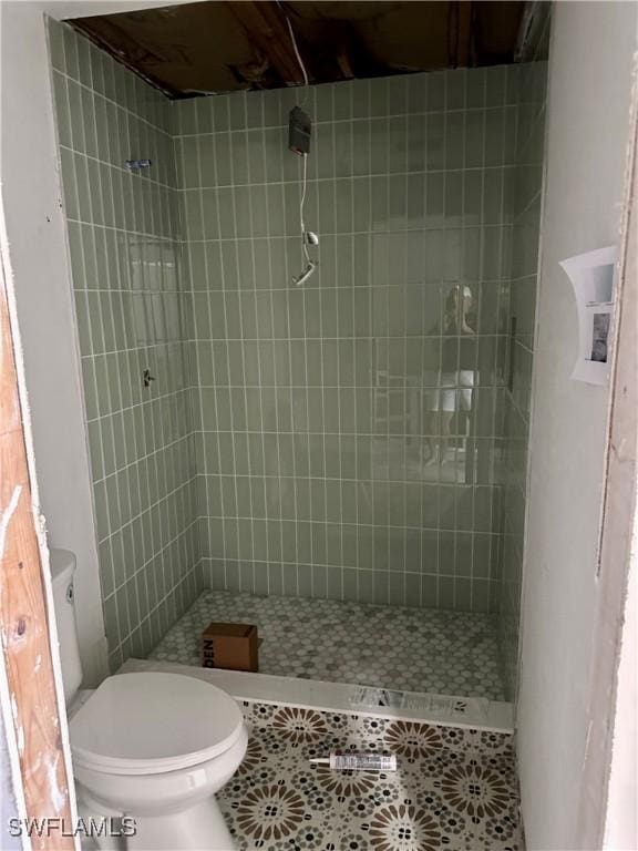 bathroom featuring a shower stall, toilet, and tile patterned floors