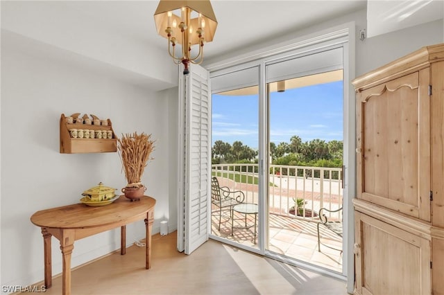 doorway featuring an inviting chandelier and light hardwood / wood-style flooring