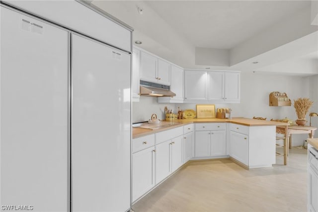 kitchen featuring white refrigerator, stovetop, light wood-type flooring, and white cabinetry