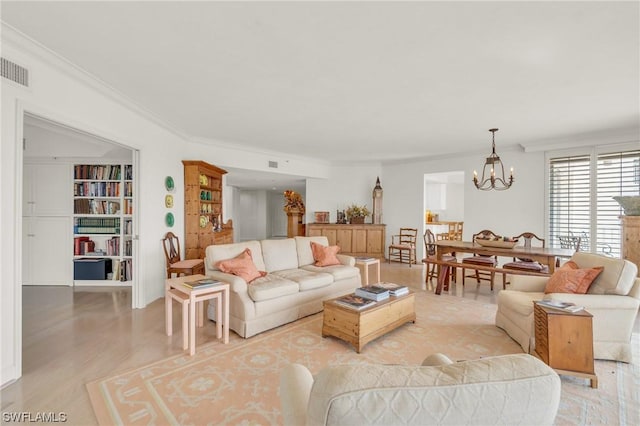 living room with a notable chandelier, light hardwood / wood-style floors, and crown molding