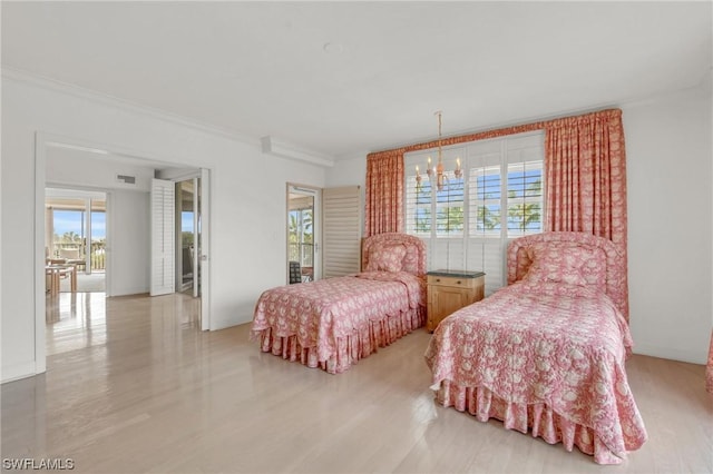 bedroom with ornamental molding, a notable chandelier, and light hardwood / wood-style floors