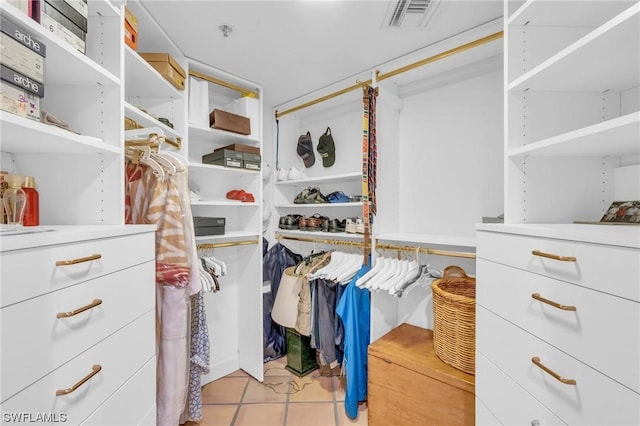 walk in closet with light tile patterned floors